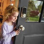 Child opening door with a smart door lock installed.