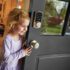 Child opening door with a smart door lock installed.